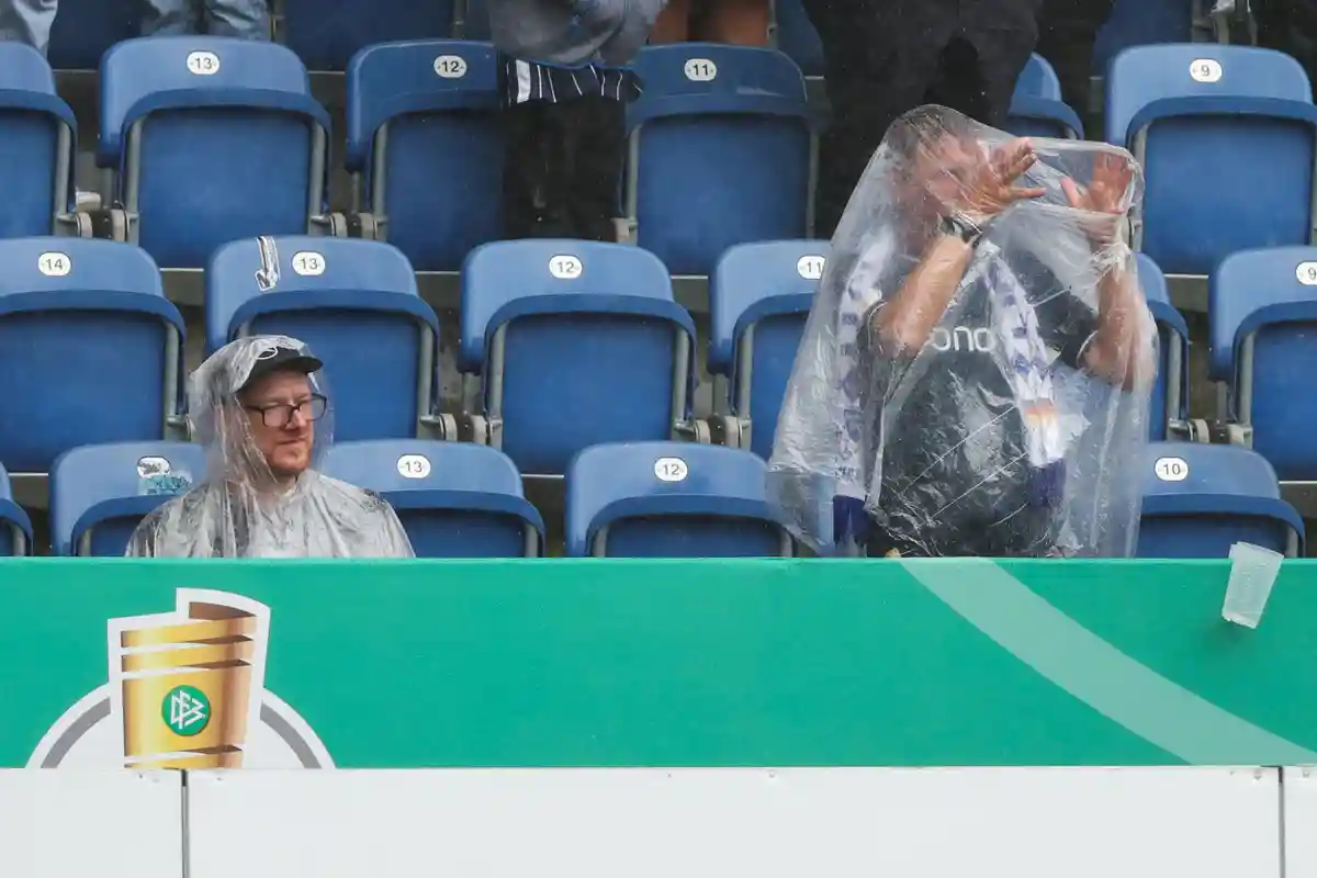 Дождь на кубковом матче:Зрители укрываются от дождя.