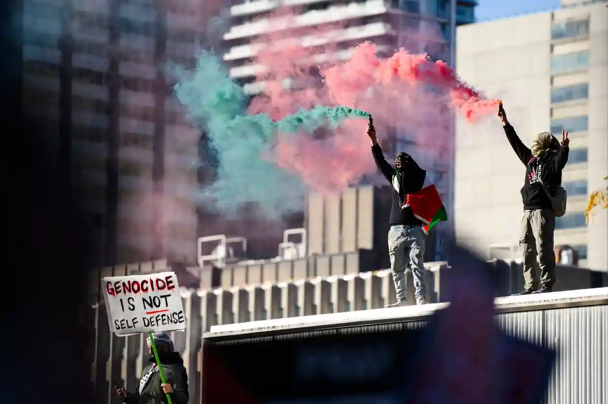Дымовые сигналы:Люди принимают участие в демонстрации в поддержку палестинцев в Торонто.