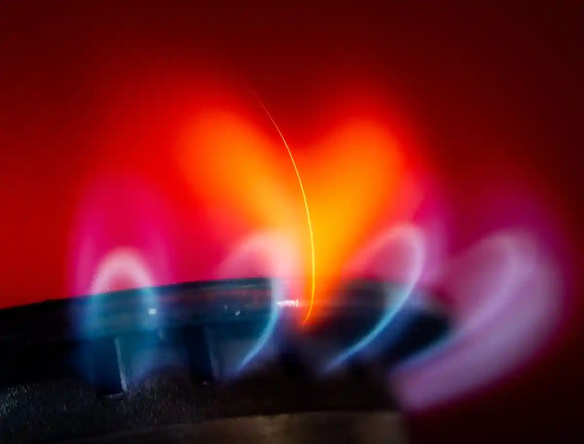 Газовая варочная панель с пламенем:На кухне горит пламя газовой конфорки.