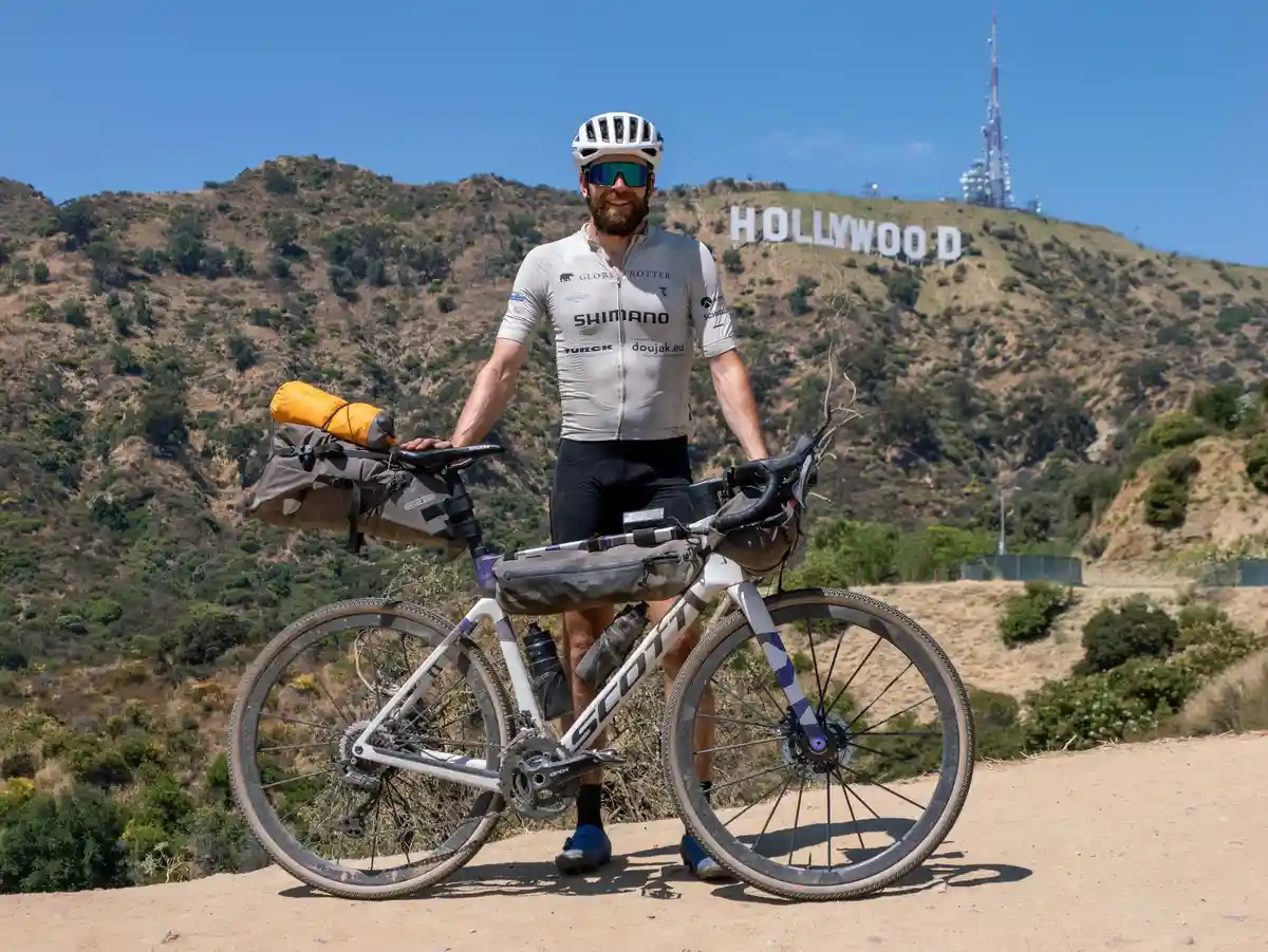 Йонас Дайхманн:Немецкий спортсмен Йонас Дайхманн со своим велосипедом на фоне Голливудских холмов в США.