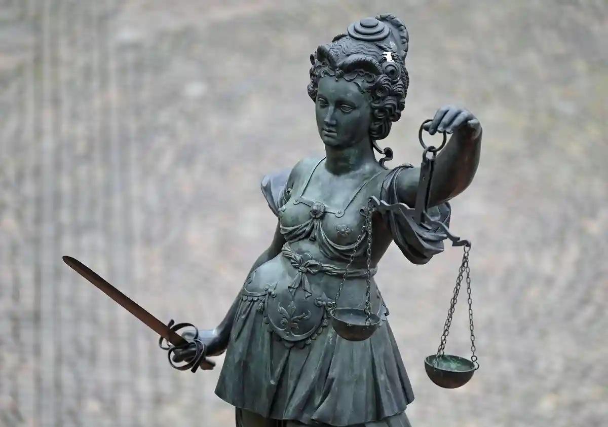 Justitia:Статуя Справедливости держит в руках весы и меч.