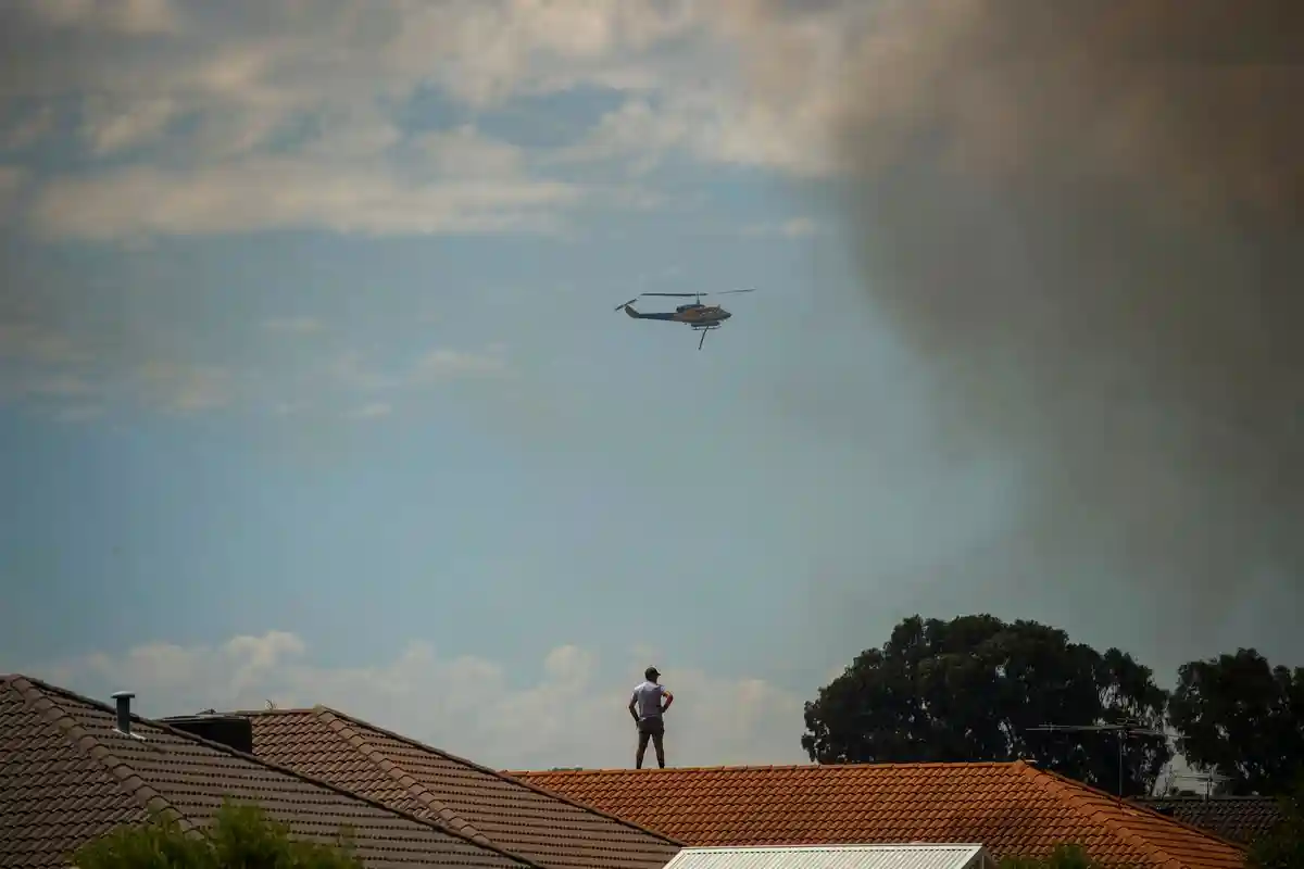 Лесные пожары в Австралии:Пожарный вертолет пытается взять под контроль пожар в Перте.