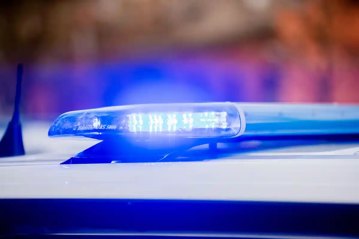 На крышу патрульного автомобиля светит синий фонарь:На крыше полицейской патрульной машины светит синий фонарь.