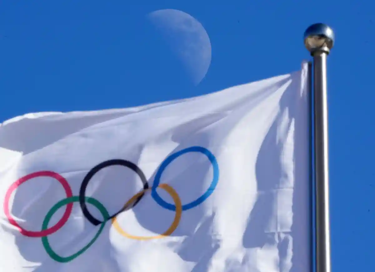 Олимпия:Олимпийский флаг развевается на ветру на фоне голубого неба.