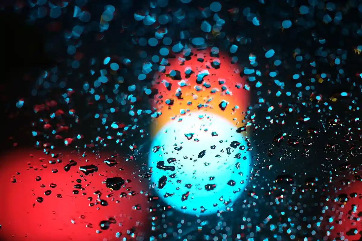 Осеннее утро:Светофор за мокрым от дождя лобовым стеклом автомобиля.