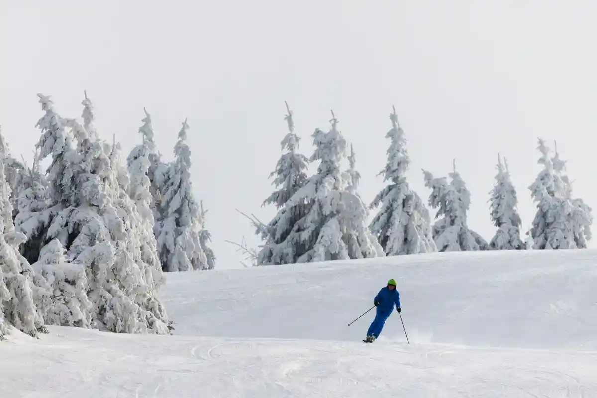 Открытие горнолыжного сезона на юго-западе:Любитель зимних видов спорта спускается на лыжах по трассе.