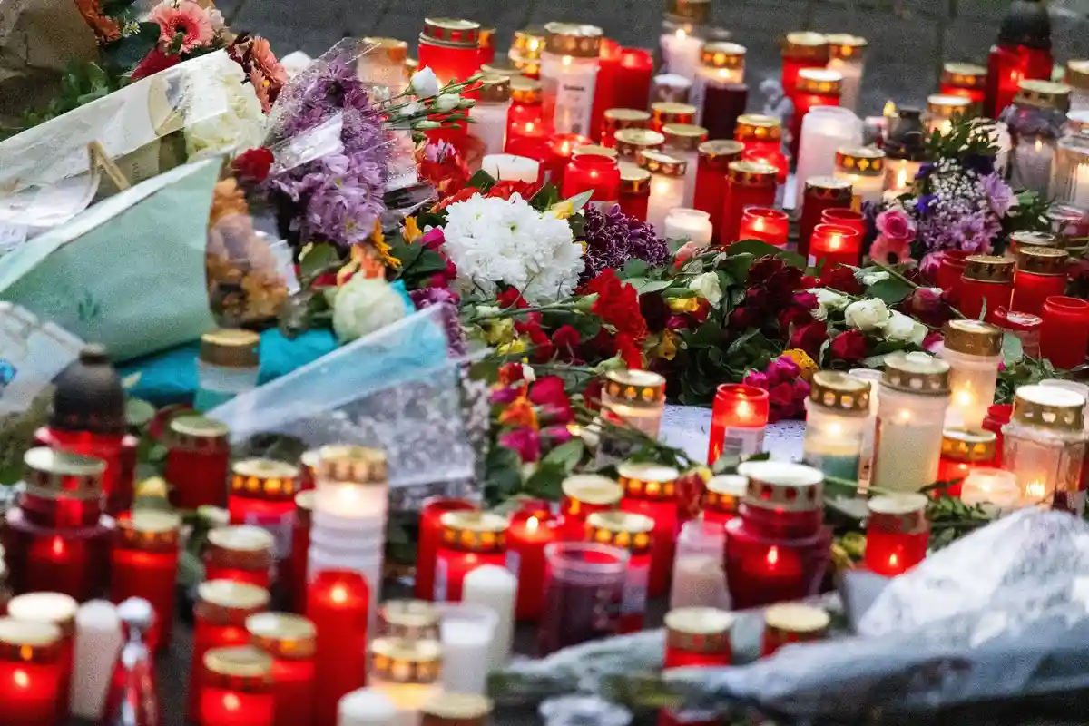 Память:Цветы и свечи лежат перед школой в Оффенбурге во время молчаливой панихиды.