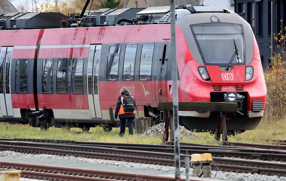 Перед предупредительной забастовкой на железной дороге - Росток:Железнодорожный служащий подходит к припаркованному поезду у главного вокзала.