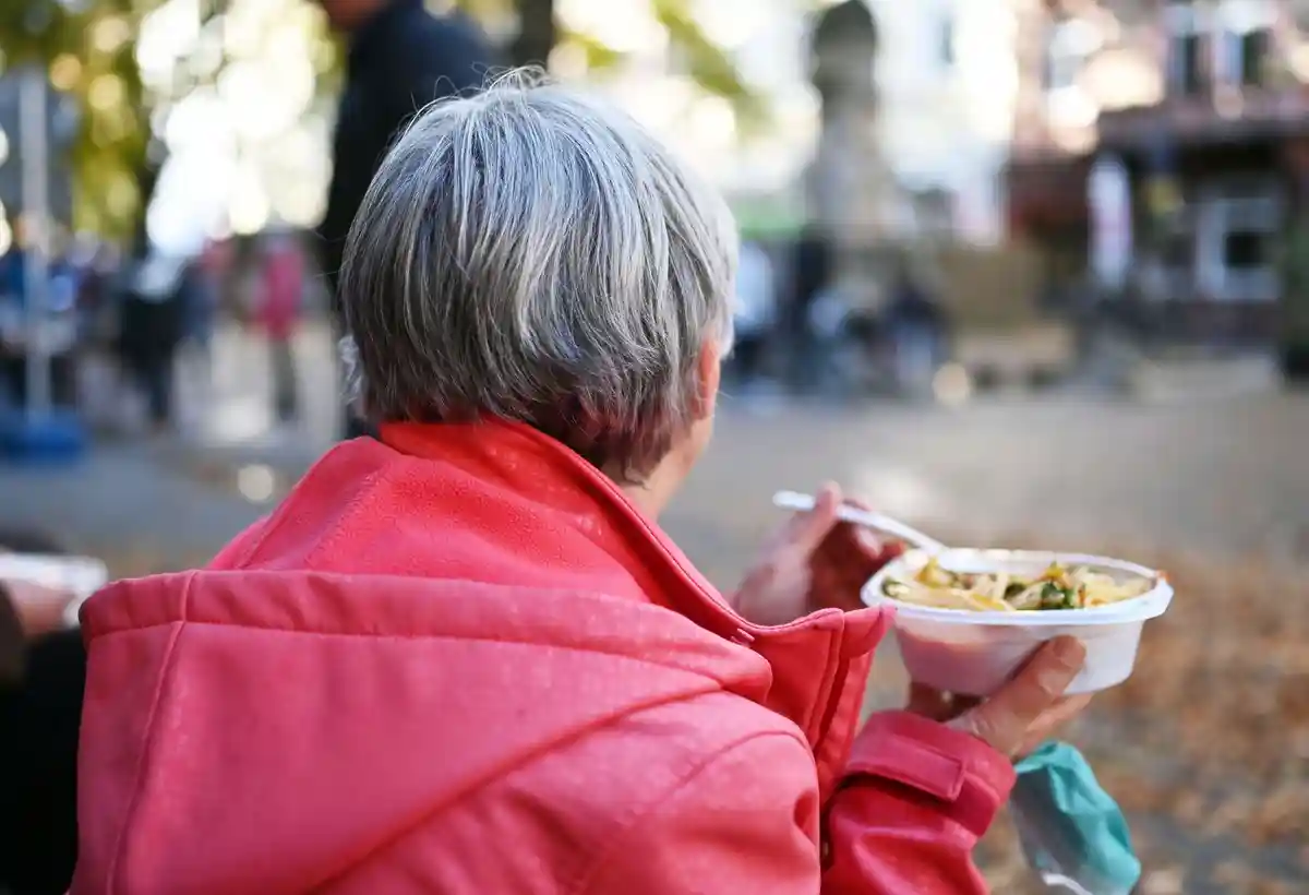 Помощь бездомным и нуждающимся в Карлсруэ:Женщина ест блюдо, переданное организацией "Herzensprojekt Obdachlosen- und Bedürftigenhilfe Bretten".