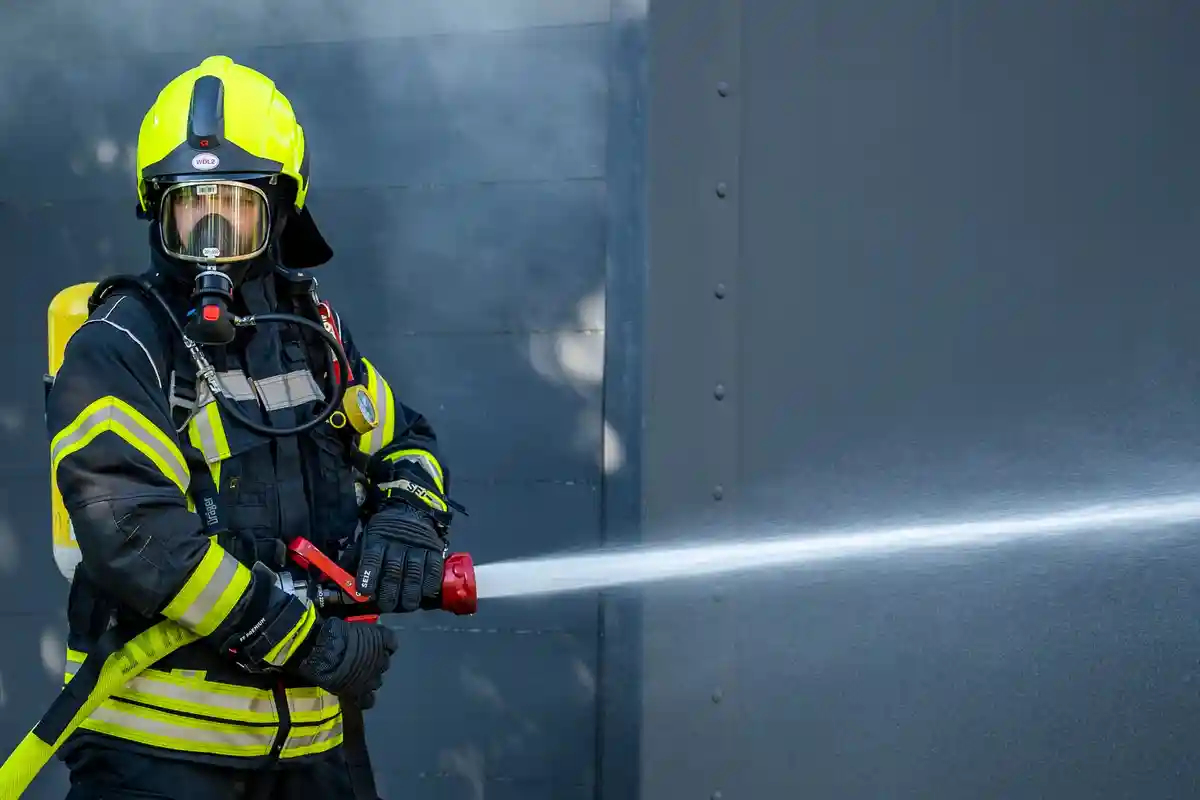 Пожарная охрана:Сотрудник пожарной бригады тушит пожар.
