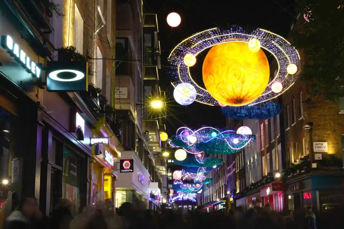 Рождественский:Карнаби-стрит в Лондоне становится рождественской: прохожие любуются разноцветными огнями и украшениями.