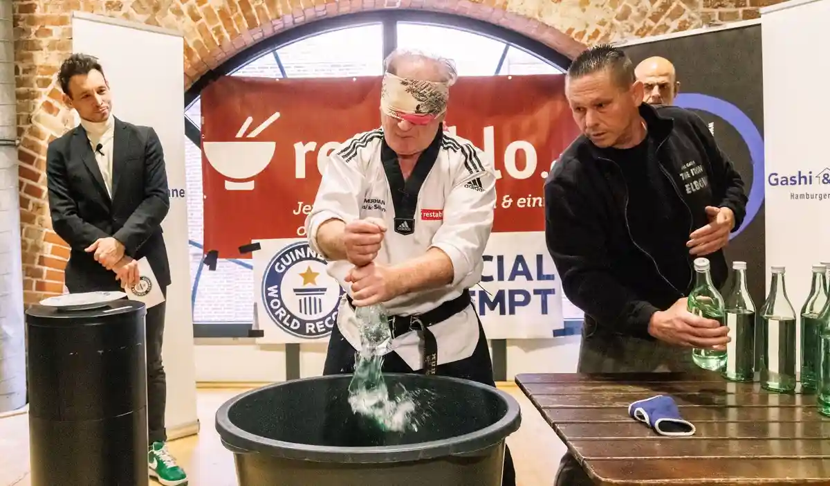 Семь попыток установить мировой рекорд за один день:Мастер боевых искусств Мухамед Кахриманович пытается разбить стеклянные бутылки с завязанными глазами, держа в руках сырое яйцо.