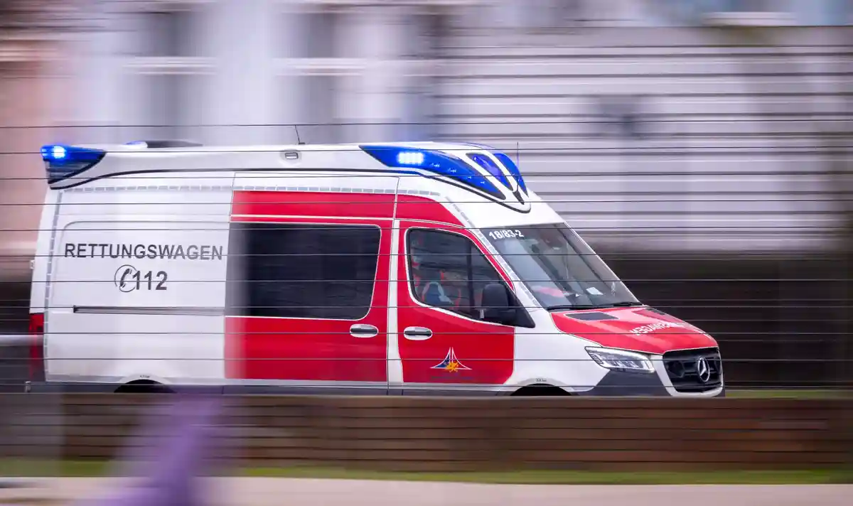 Скорая помощь:Дежурит машина скорой помощи с мигающими синими огнями.
