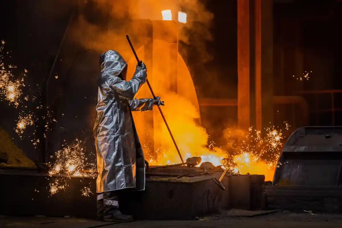 Сталь для коллективных переговоров:Работник сталелитейной компании Thyssenkrupp проверяет чугун в доменной печи №8 на территории завода.
