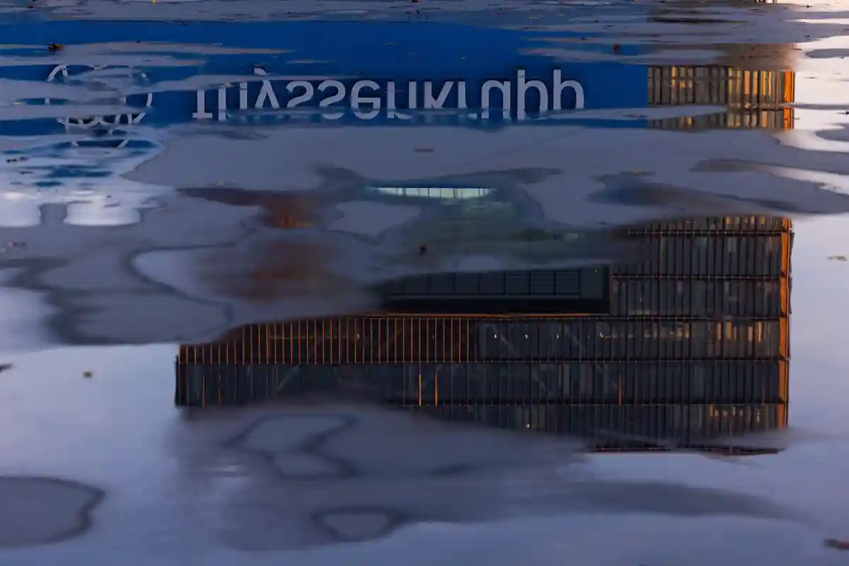 тиссенкрупп:Вид на штаб-квартиру компании Thyssenkrupp в Эссене, отражающийся в луже.