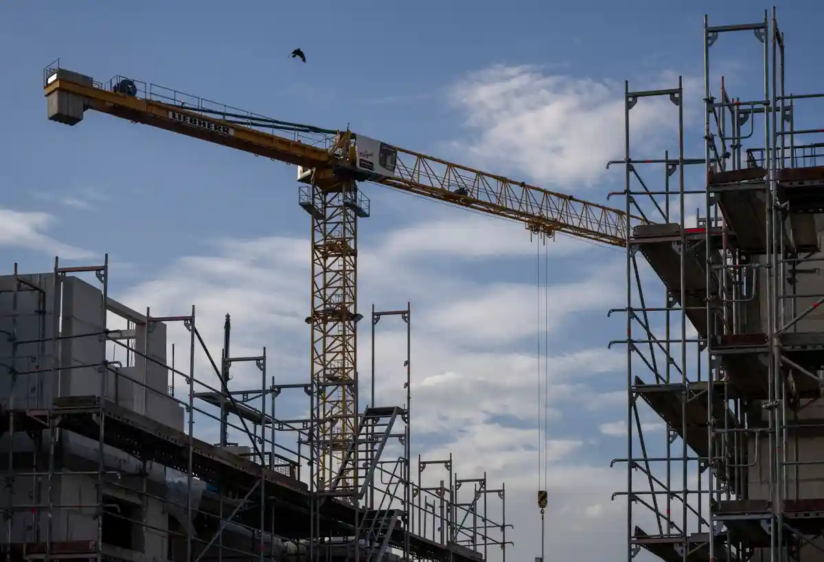 Торговля строительными материалами:Башенный кран устремлен в небо на строительной площадке: строительная отрасль особенно остро ощущает нехватку квалифицированной рабочей силы.