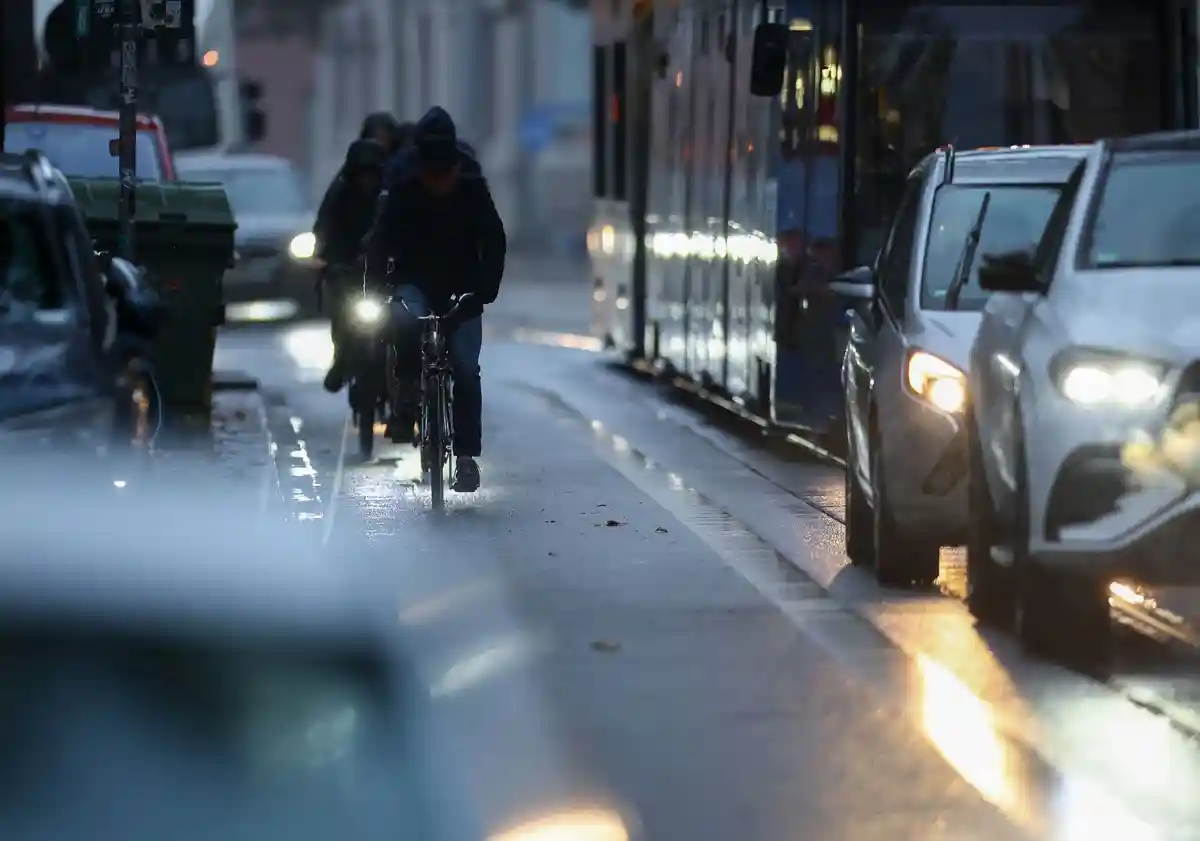 Утреннее движение в час пик:Велосипедисты выезжают в утренние пробки в час пик под дождем.