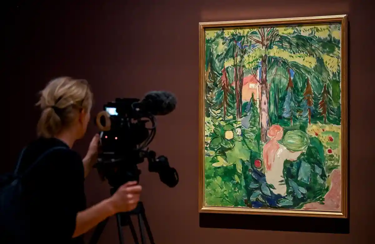 Выставка "Мунк. Жизненный пейзаж":Молодая женщина снимает картину художника Эдварда Мунка "Женщина с тыквой".