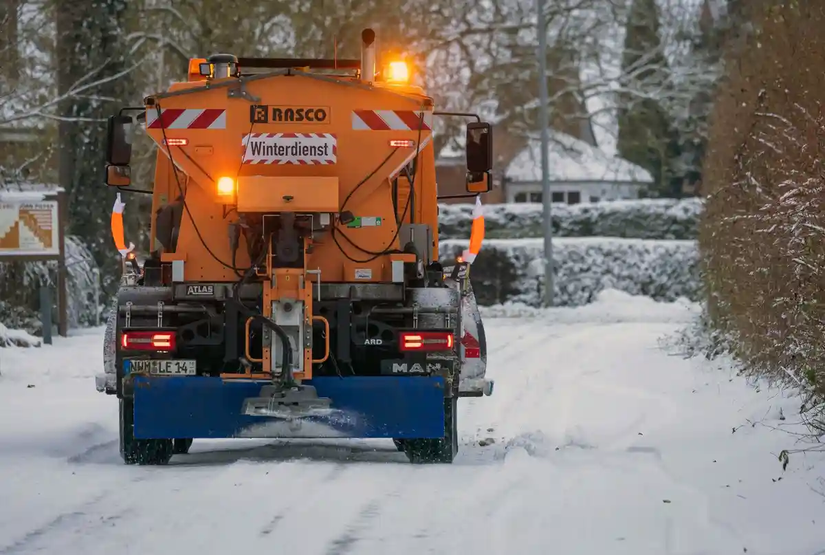 Зимний сервис:Снегоуборочная машина расчищает дорогу.