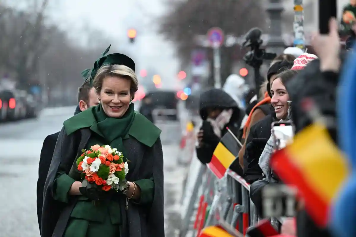 Бельгийская королевская чета:Королева Бельгии Матильда приветствует ожидающих зрителей с бельгийскими флагами у Бранденбургских ворот.