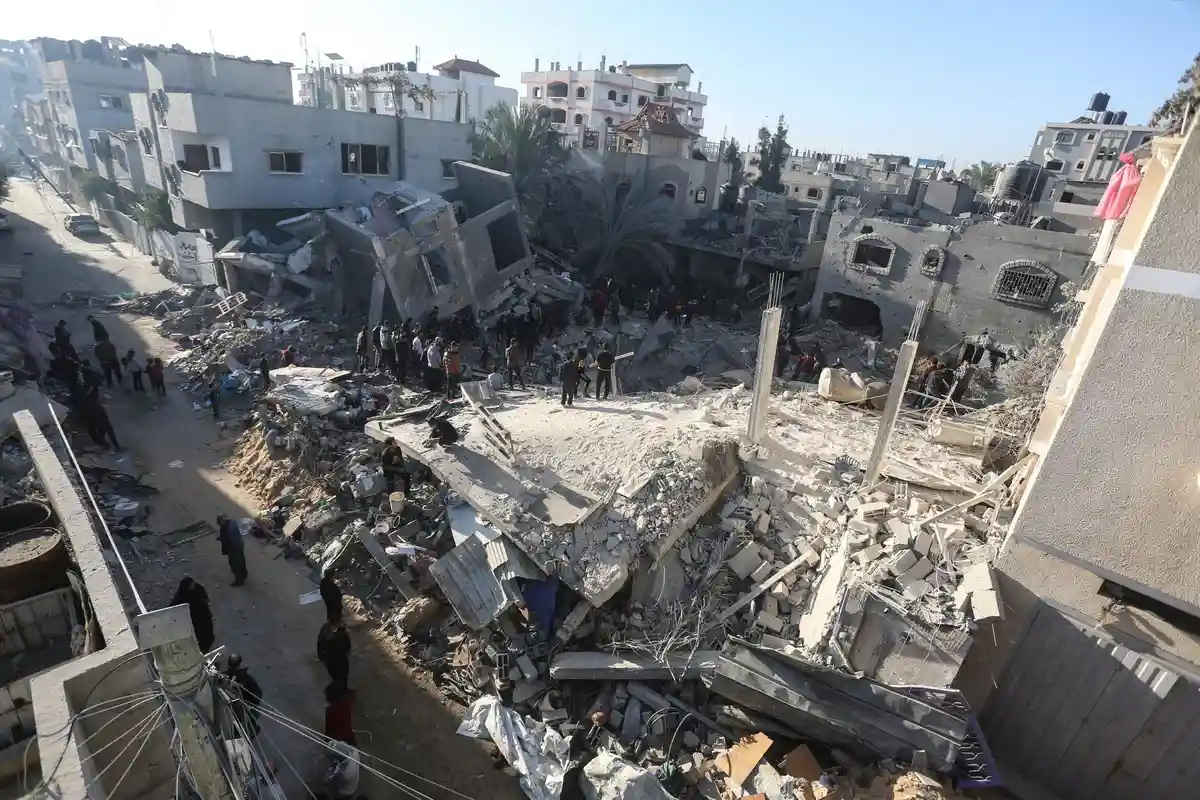 Ближневосточный конфликт:Палестинцы ищут среди обломков здания выживших после израильской бомбардировки.