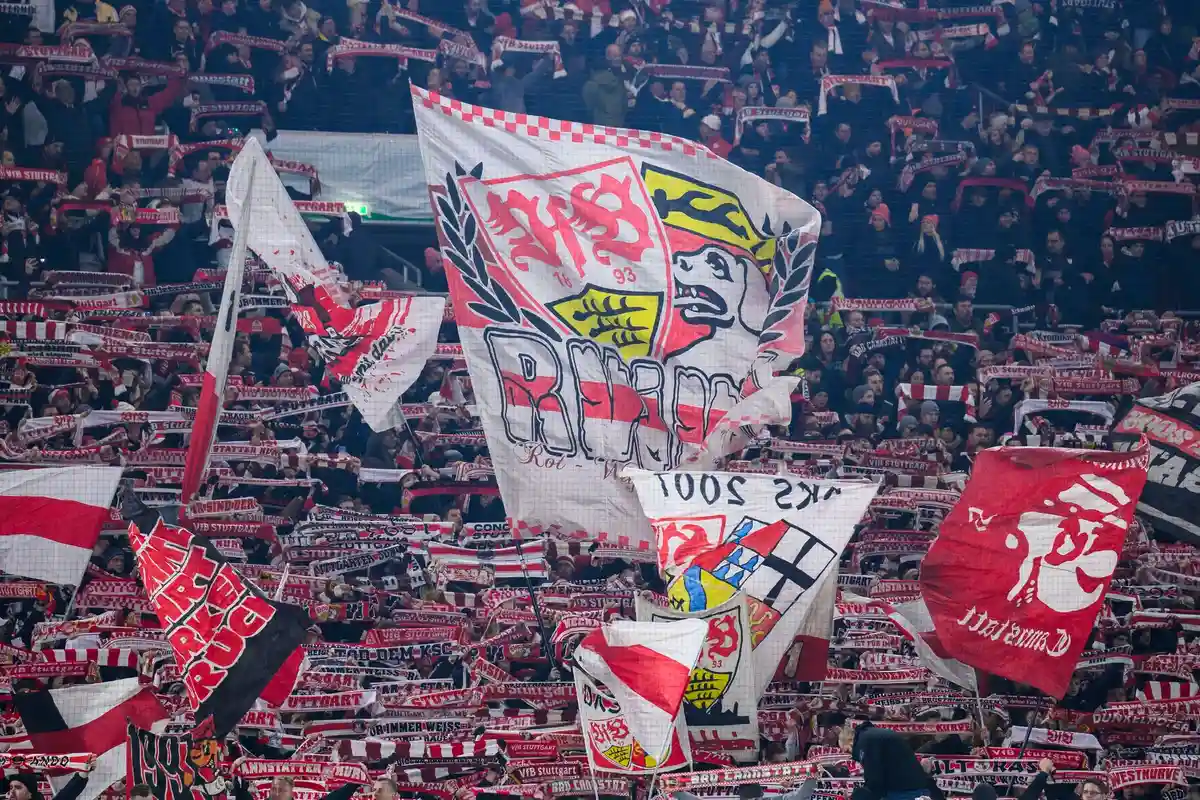Болельщики ВФБ Штутгарт:В фанатском блоке развевается флаг с логотипом VfB Stuttgart.