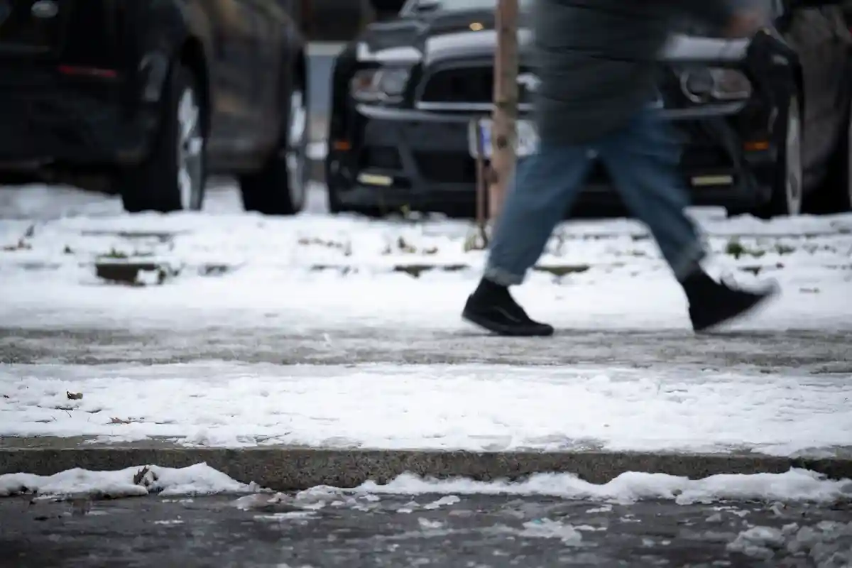Черный лед в Берлине:Человек идет по тротуару.