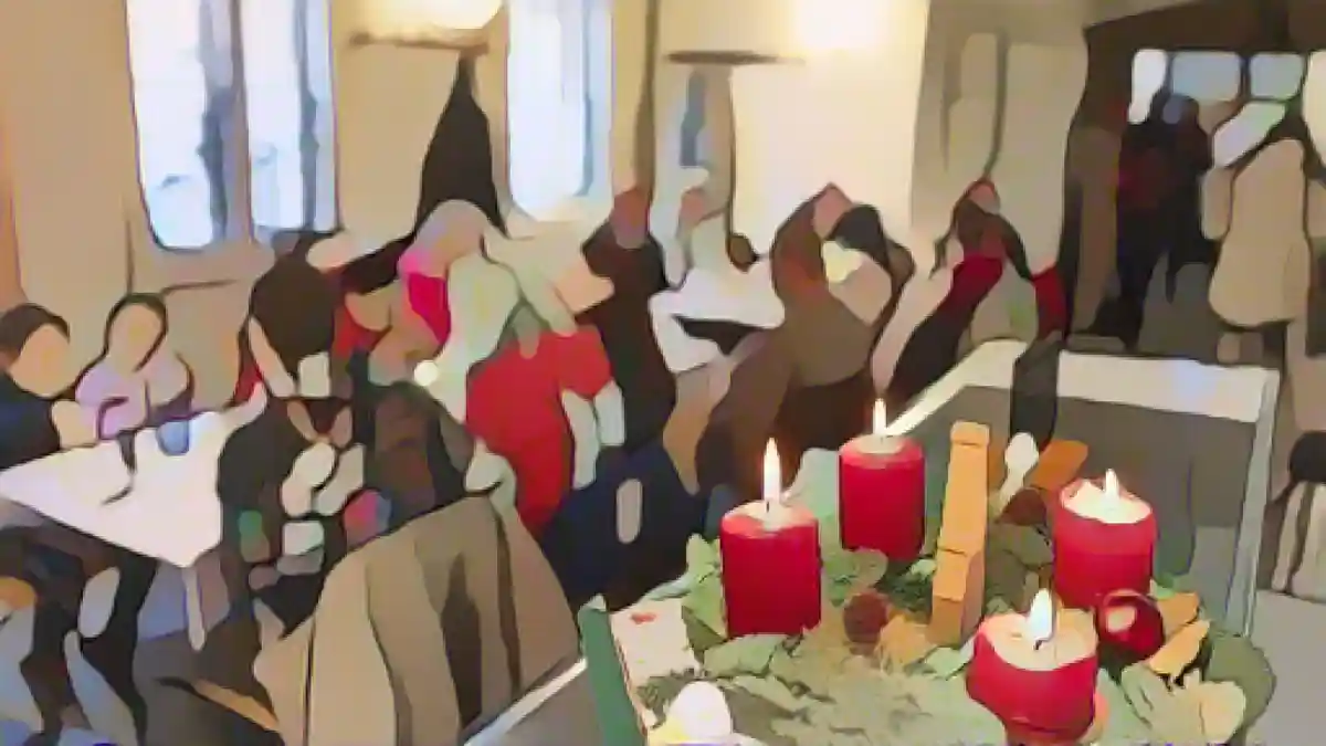 Четыре свечи горят в венке Адвента на рождественском празднике в суповой кухне Caritas.:Четыре свечи горят на венке Адвента на рождественском празднике в столовой "Каритас". Фото