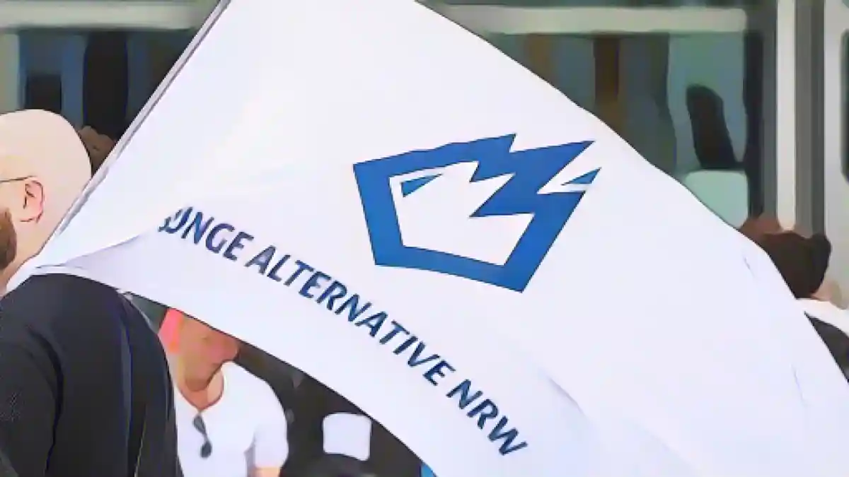 Член "Молодой альтернативы" (JA) несет баннер с логотипом организации на предвыборном митинге в Дортмунде.:Член "Молодой альтернативы" (JA) несет флаг с логотипом организации на предвыборном митинге в Дортмунде. Фото