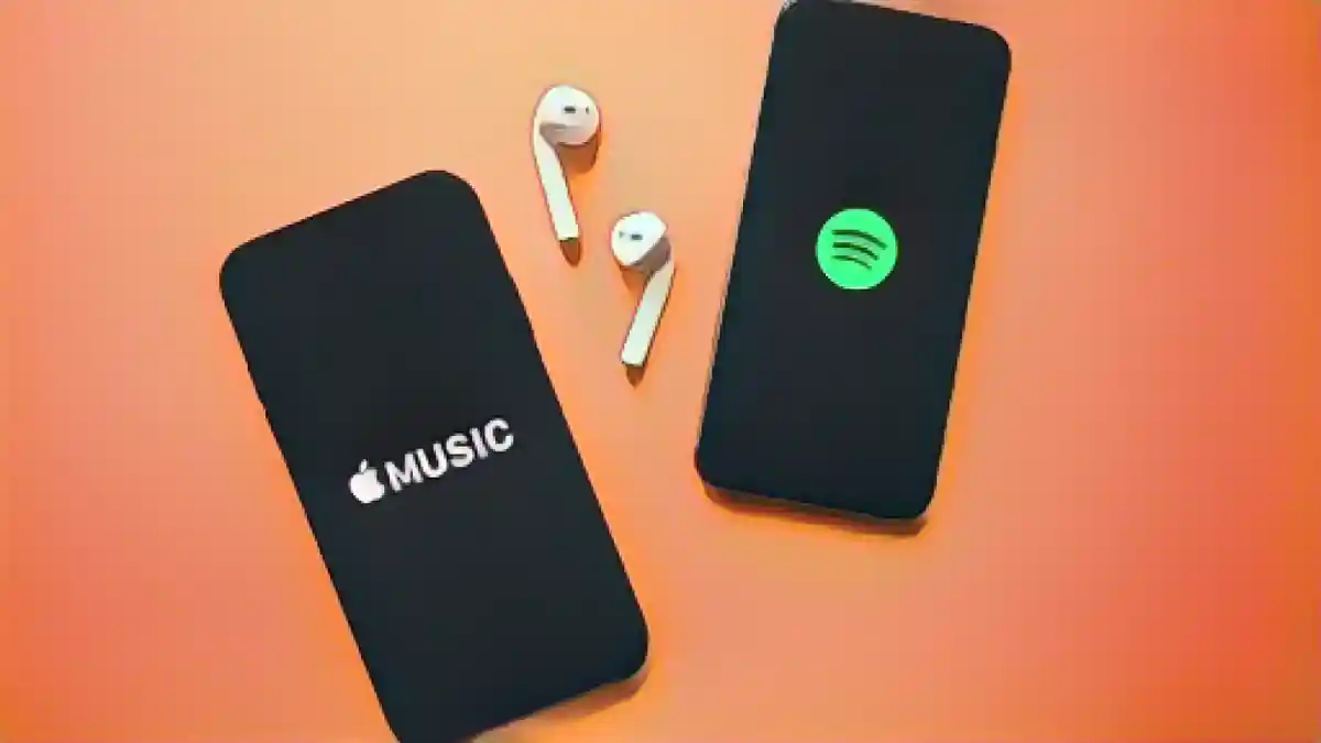 Два смартфона, один с логотипом Apple Music, другой с логотипом Spotify:Как выбрать между Spotify и Apple Music