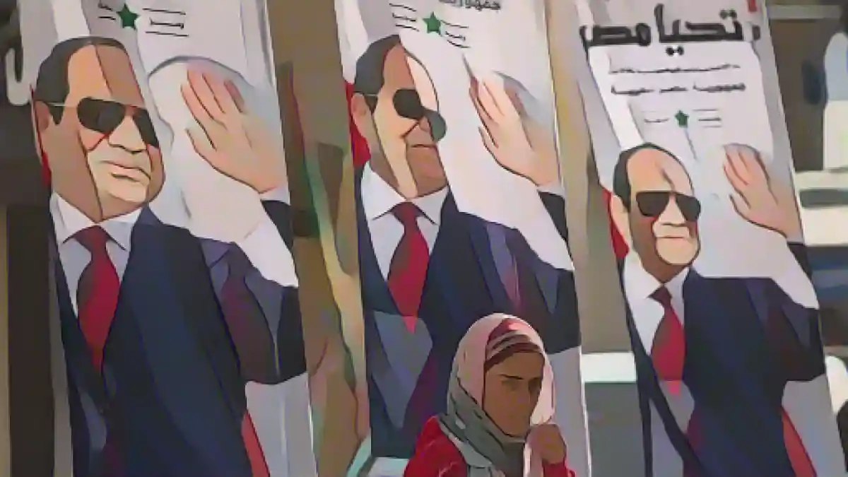 Египет: женщина проходит мимо плакатов с изображением президента и кандидата в президенты Ас-Сиси.:С воскресенья в Египте проходит голосование, и действующий президент ас-Сиси, скорее всего, снова победит на выборах