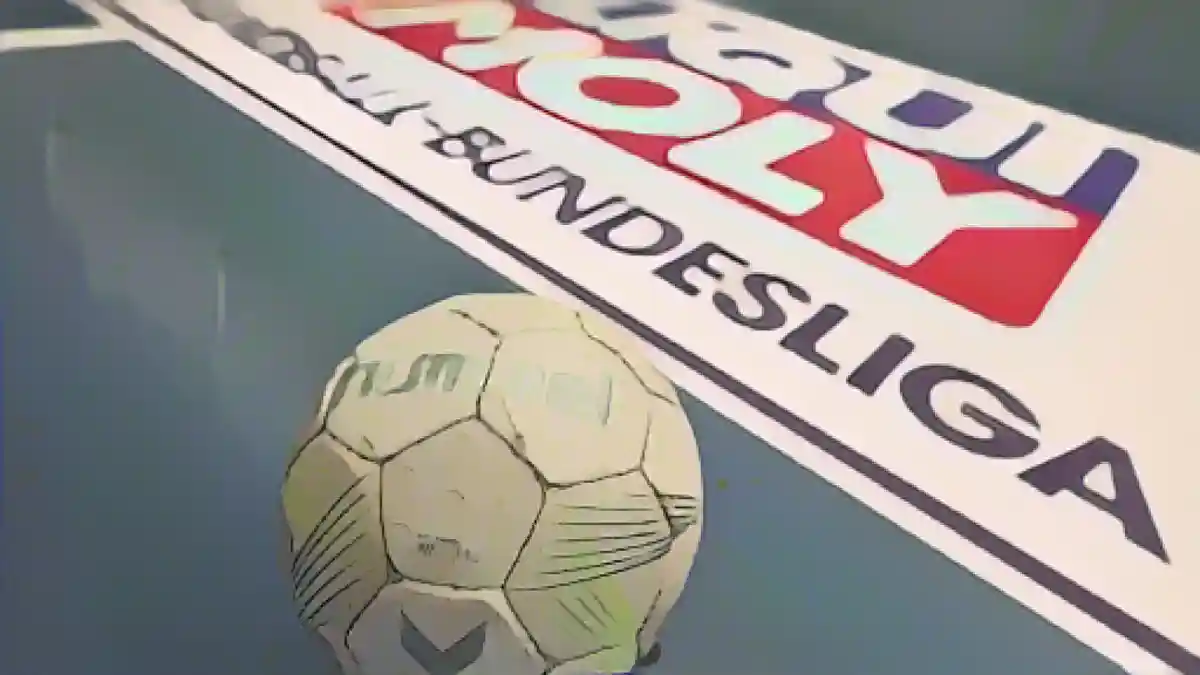 Гандбольный мяч лежит на полу, а за ним - логотип Гандбольной бундеслиги (HBL).:Гандбольный мяч лежит на полу, за ним логотип Бундеслиги по гандболу (HBL). Фото