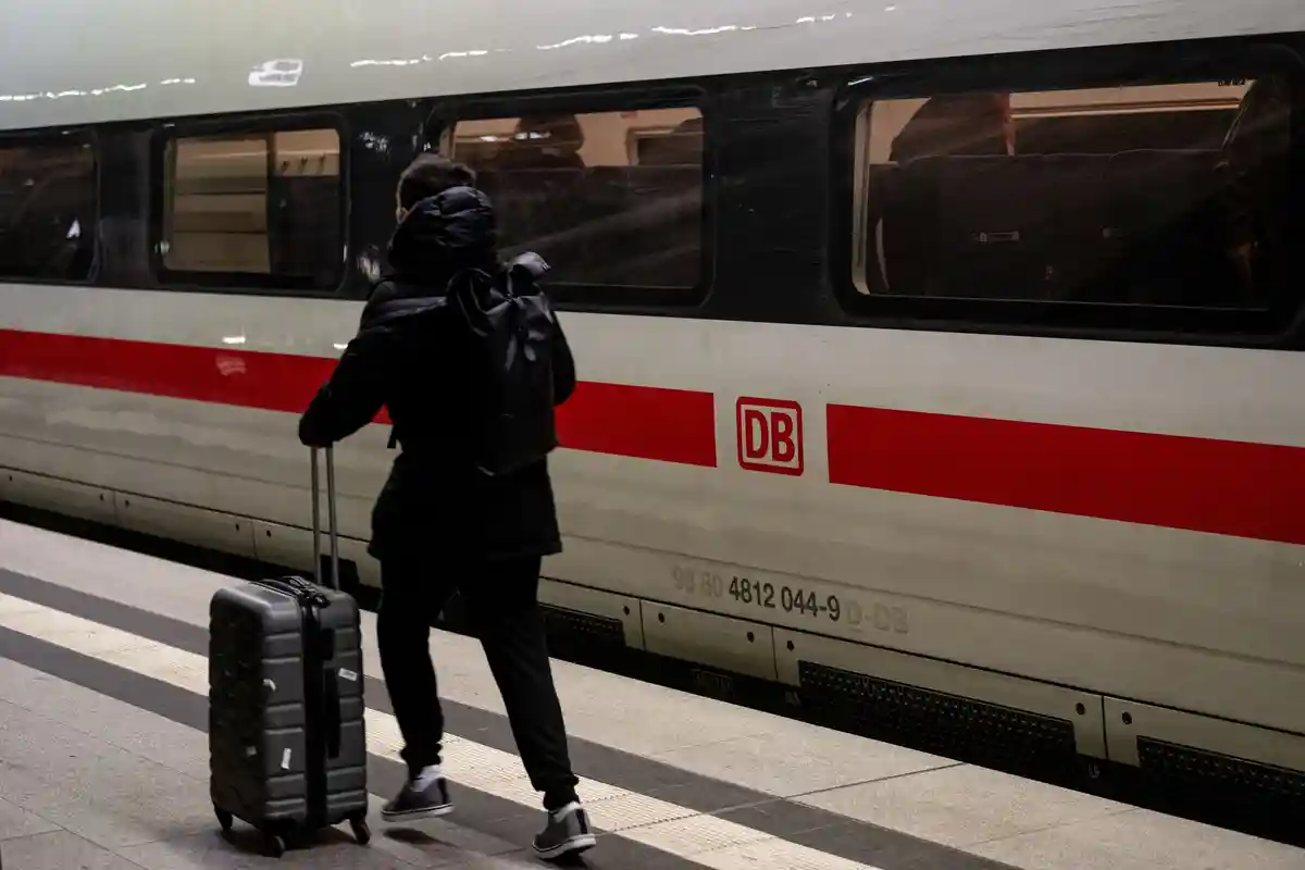 ICE:Люди с чемоданами идут по железнодорожным путям ранним утром.