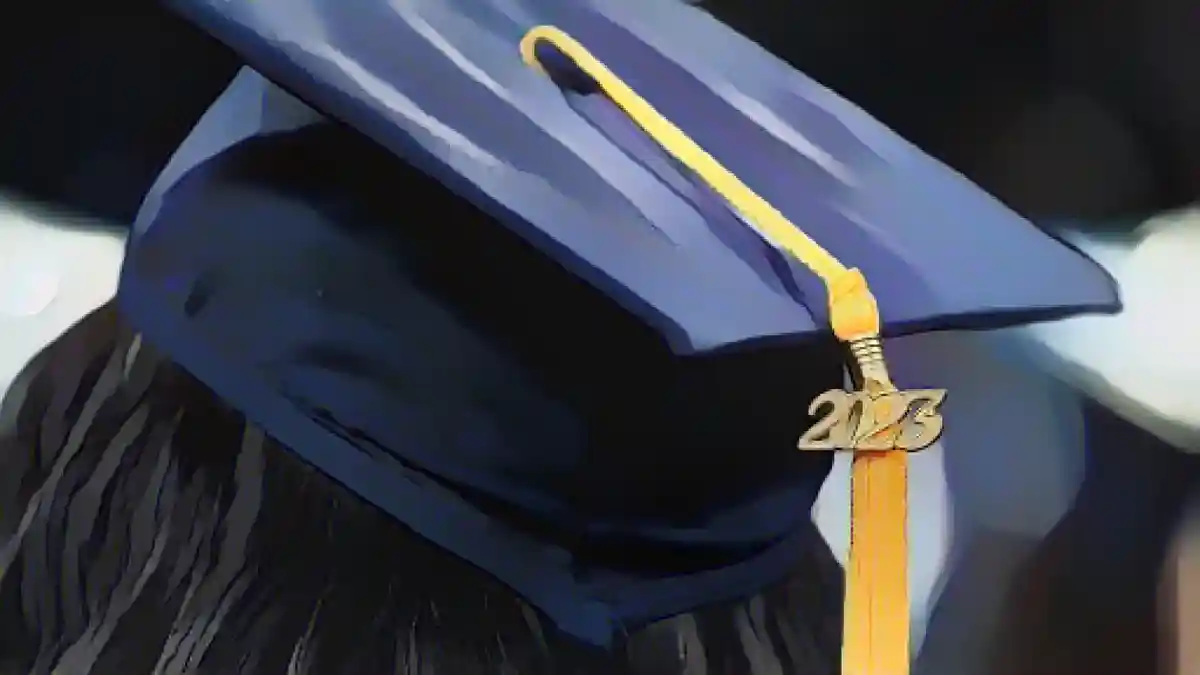 Кисточка с надписью 2023 лежит на шапочке выпускника, когда студенты идут в процессии на выпускной вечер Университета Говарда в Вашингтоне, округ Колумбия, в субботу, 13 мая 2023 года.: