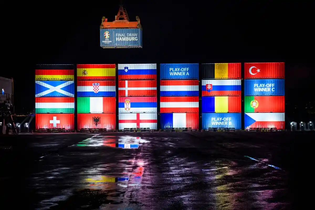 Контейнеры для ЭМ в порту Гамбурга:Контейнеры, украшенные национальными флагами, уложены в штабеля в О'Свальдкай в порту Гамбурга в честь жеребьевки чемпионата Европы.