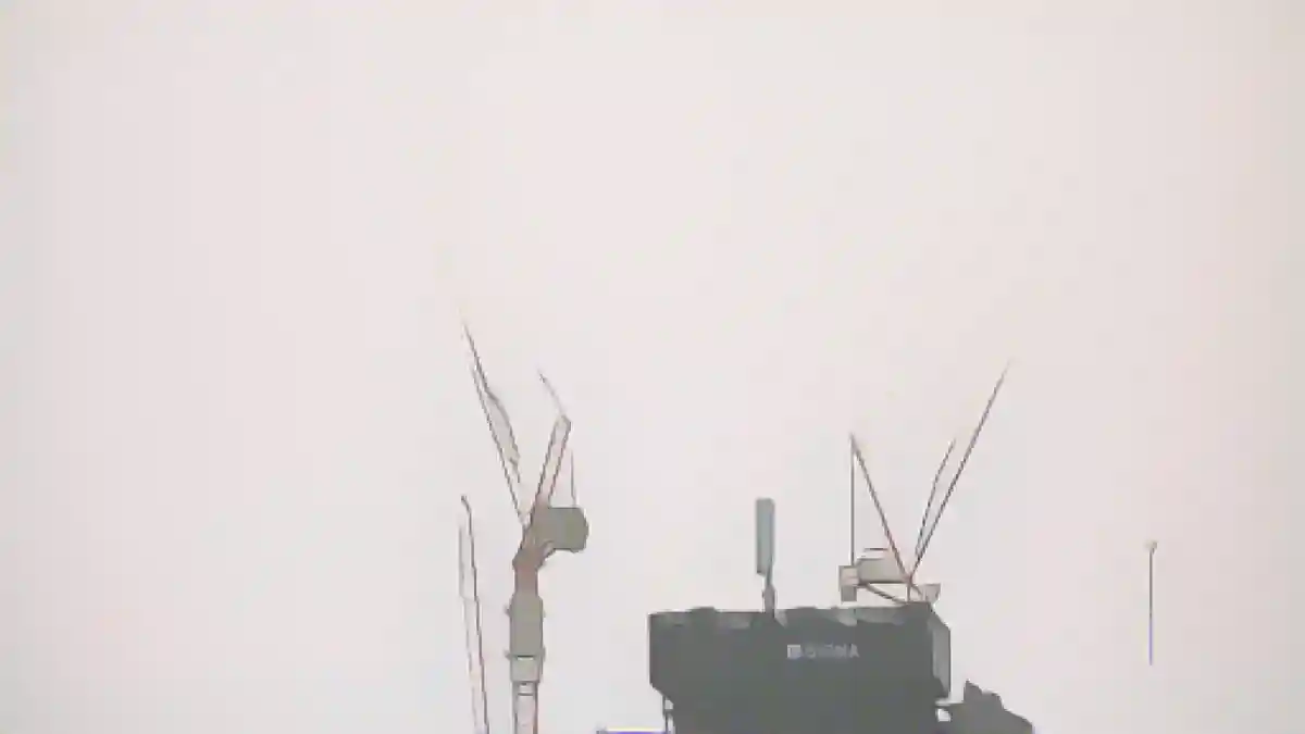 Краны над вершиной строительной площадки Elbtower в Хафен-Сити исчезают в тумане.:Краны над вершиной строительной площадки Elbtower в HafenCity исчезают в тумане. Фото