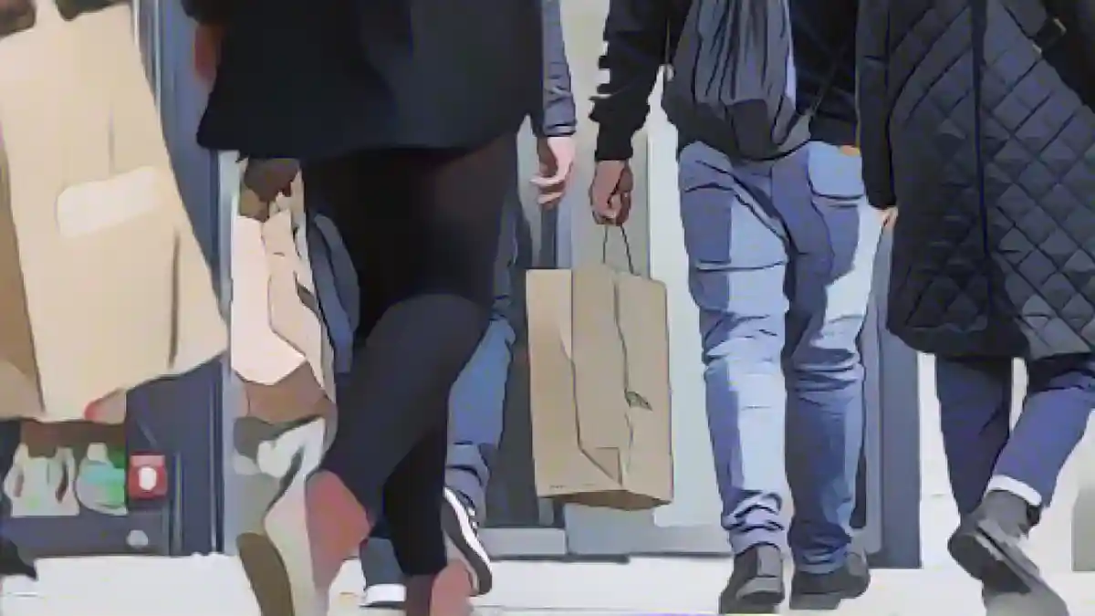 Люди идут по улице с сумками для покупок.:Люди идут по улице с сумками для покупок. Фото