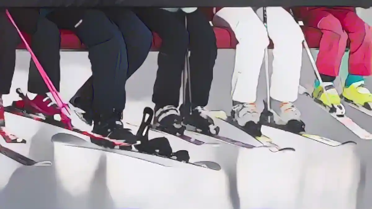 Лыжники сидят в подъемнике по пути на горнолыжный склон.:Лыжники сидят в подъемнике на пути к горнолыжному склону. Фото