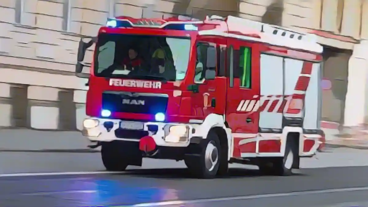 На дороге стоит пожарная машина с мигающими синими огнями.:Пожарная машина с мигающими синими огнями на дороге. Фото
