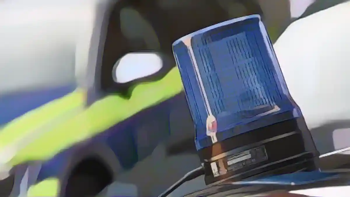 На крыше полицейского автомобиля виден мигающий синий фонарь.:Синий фонарь виден на крыше полицейской машины скорой помощи. Фото