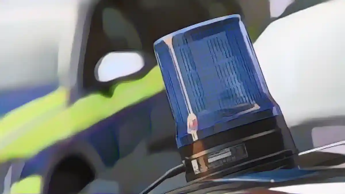 На крыше полицейского автомобиля виден мигающий синий фонарь.:Синий фонарь виден на крыше полицейской машины скорой помощи. Фото