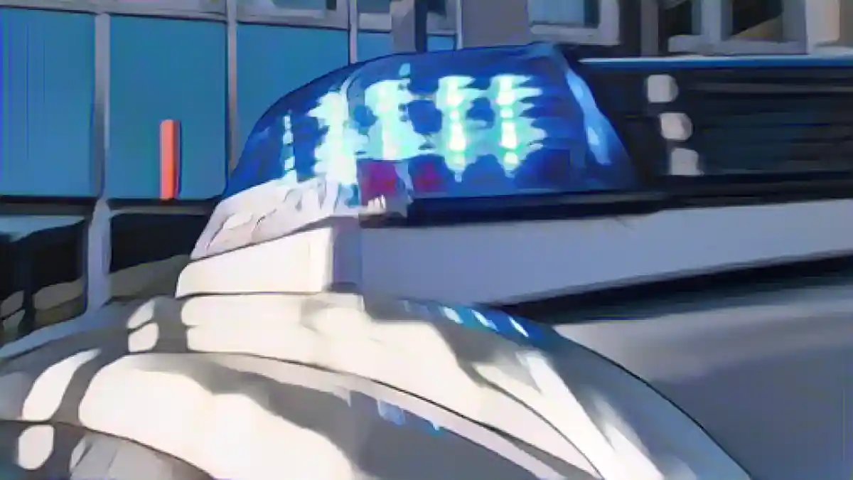 На крыше полицейской машины горит мигающий синий фонарь.:Синий фонарь светит на крышу полицейской машины. Фото