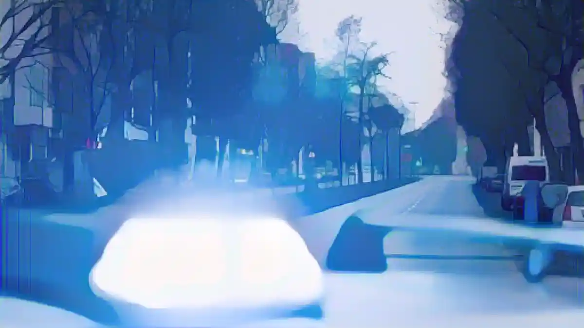 На крыше полицейской патрульной машины светит синий фонарь.:Синий фонарь светит на крышу полицейской патрульной машины. Фото