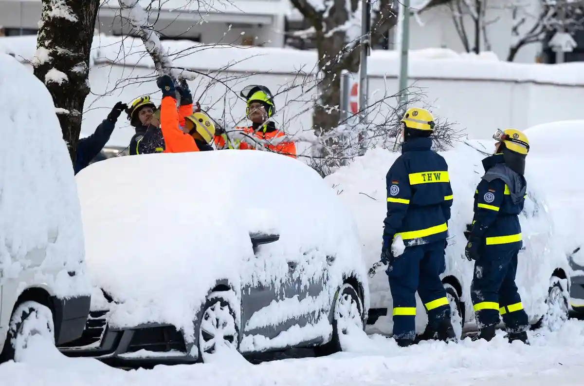 Наступление зимы на юге Германии:Сотрудники аварийной службы Федерального агентства по технической помощи (THW) осматривают деревья, поврежденные снегом на одной из улиц.