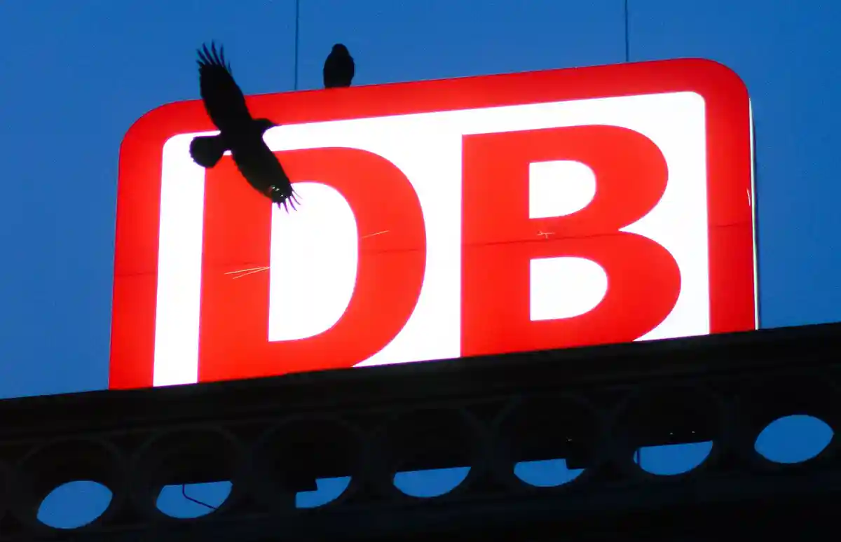 Немецкая железная дорога:Ворон летит перед логотипом Deutsche Bahn на центральном вокзале Ганновера.