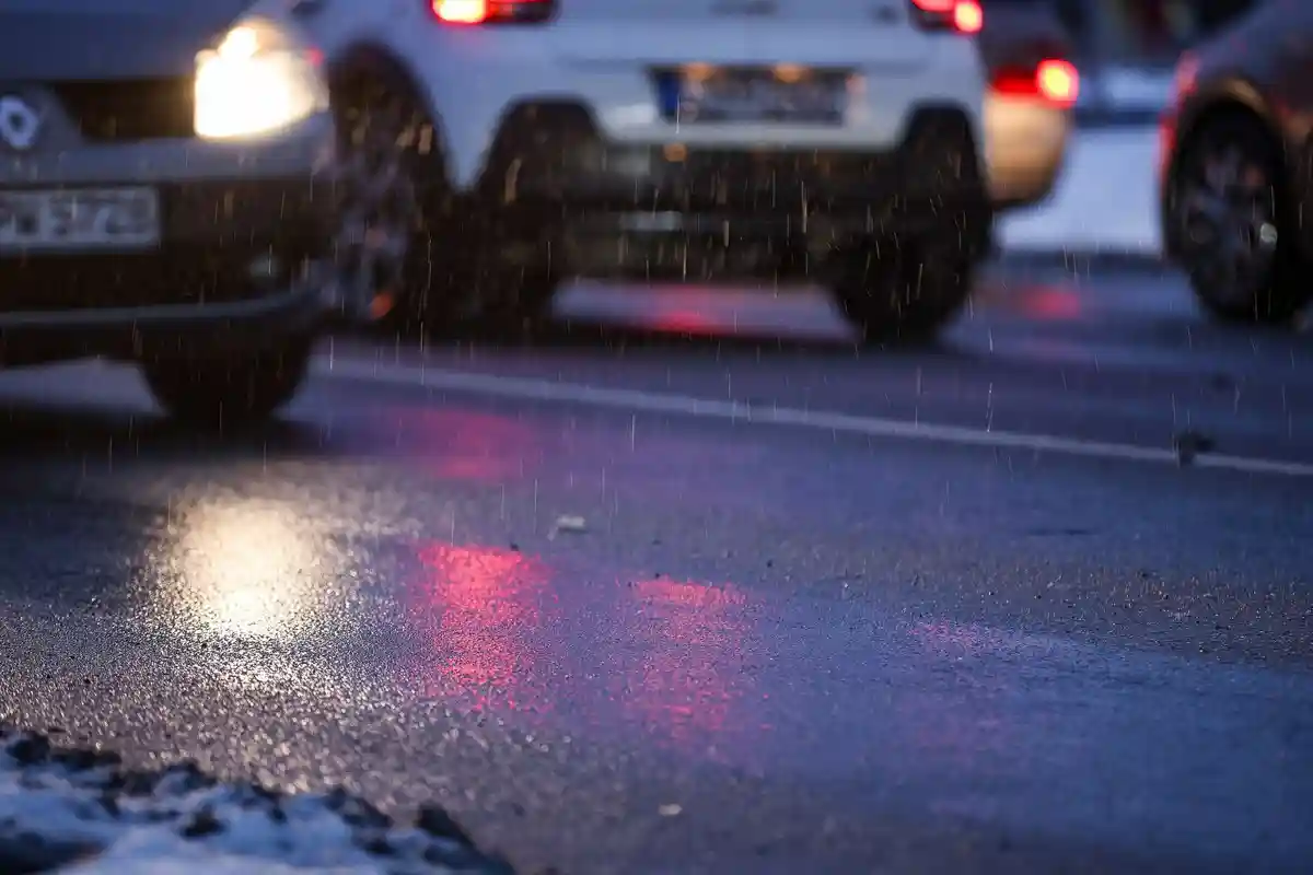 Опасность черного льда:Машины едут утром под дождем и скользким снегом.