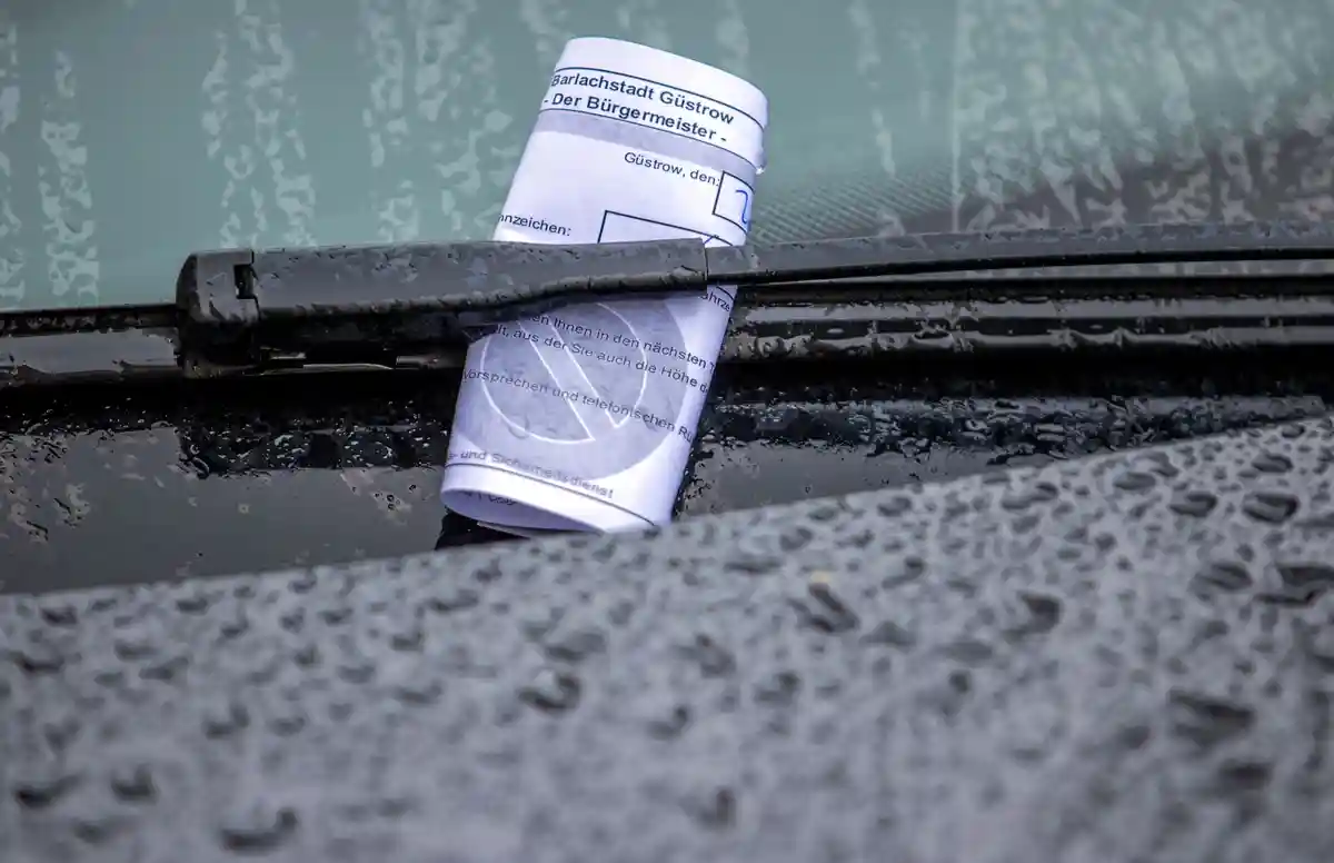 Парковочный талон:Парковочный талон застрял под стеклоочистителем автомобиля, который был неправильно припаркован под дождем.