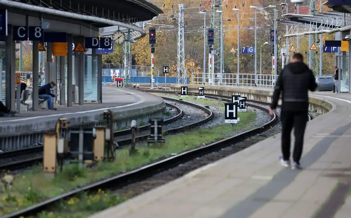 Перед предупредительной забастовкой на железной дороге:Мужчина идет по пустой платформе железнодорожного вокзала.