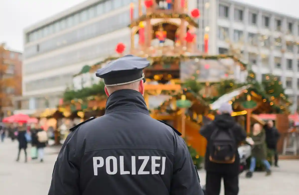 Полицейский на посту:Полицейский стоит на рождественском рынке.