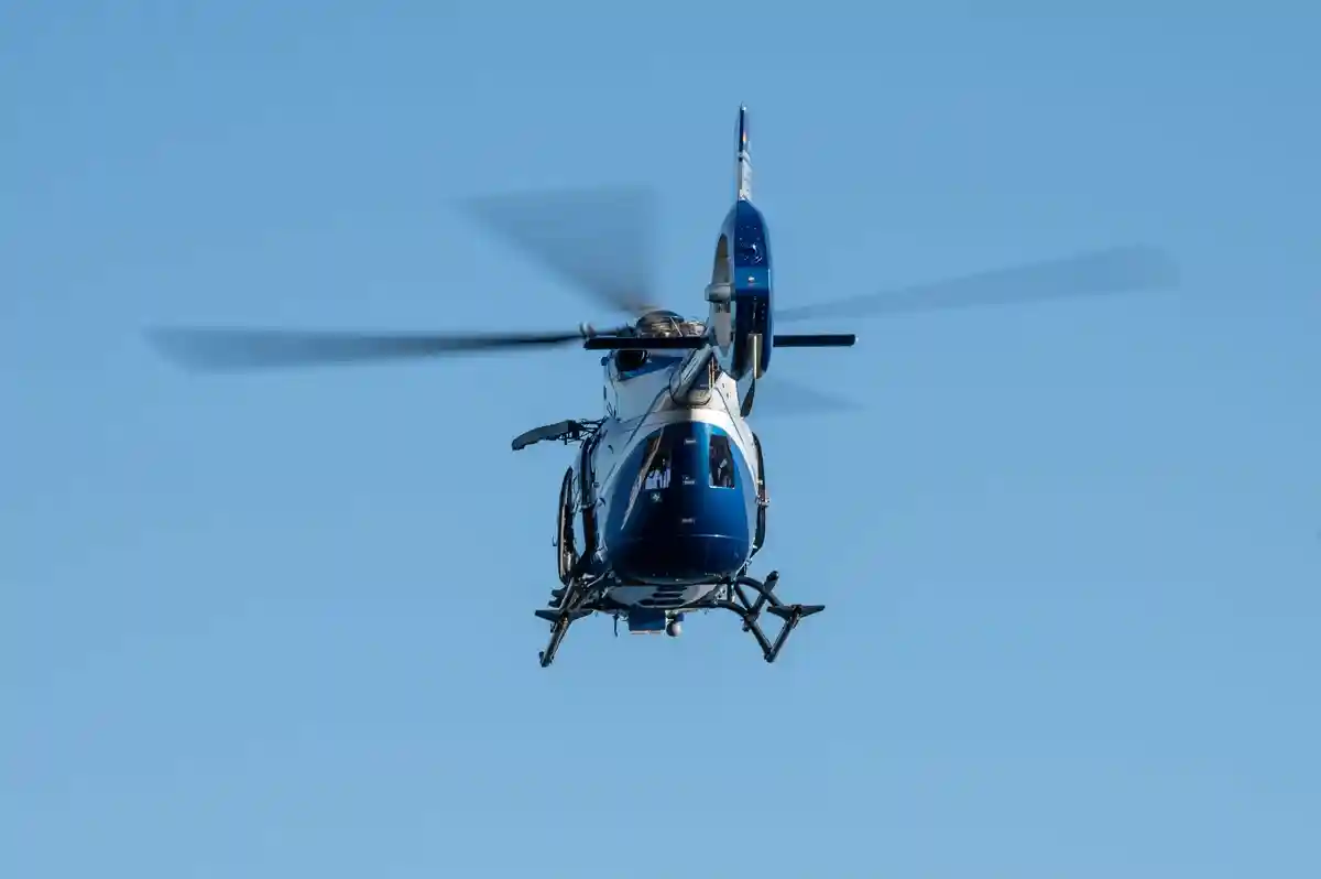 Полицейский вертолет:Полицейский вертолет пролетает над водоемом в рамках программы обучения.